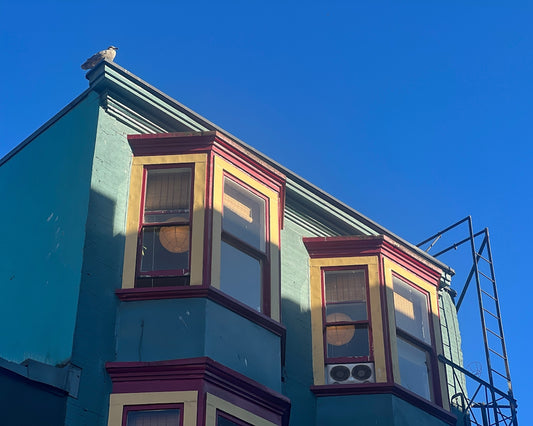 a blue building with red trim and windows